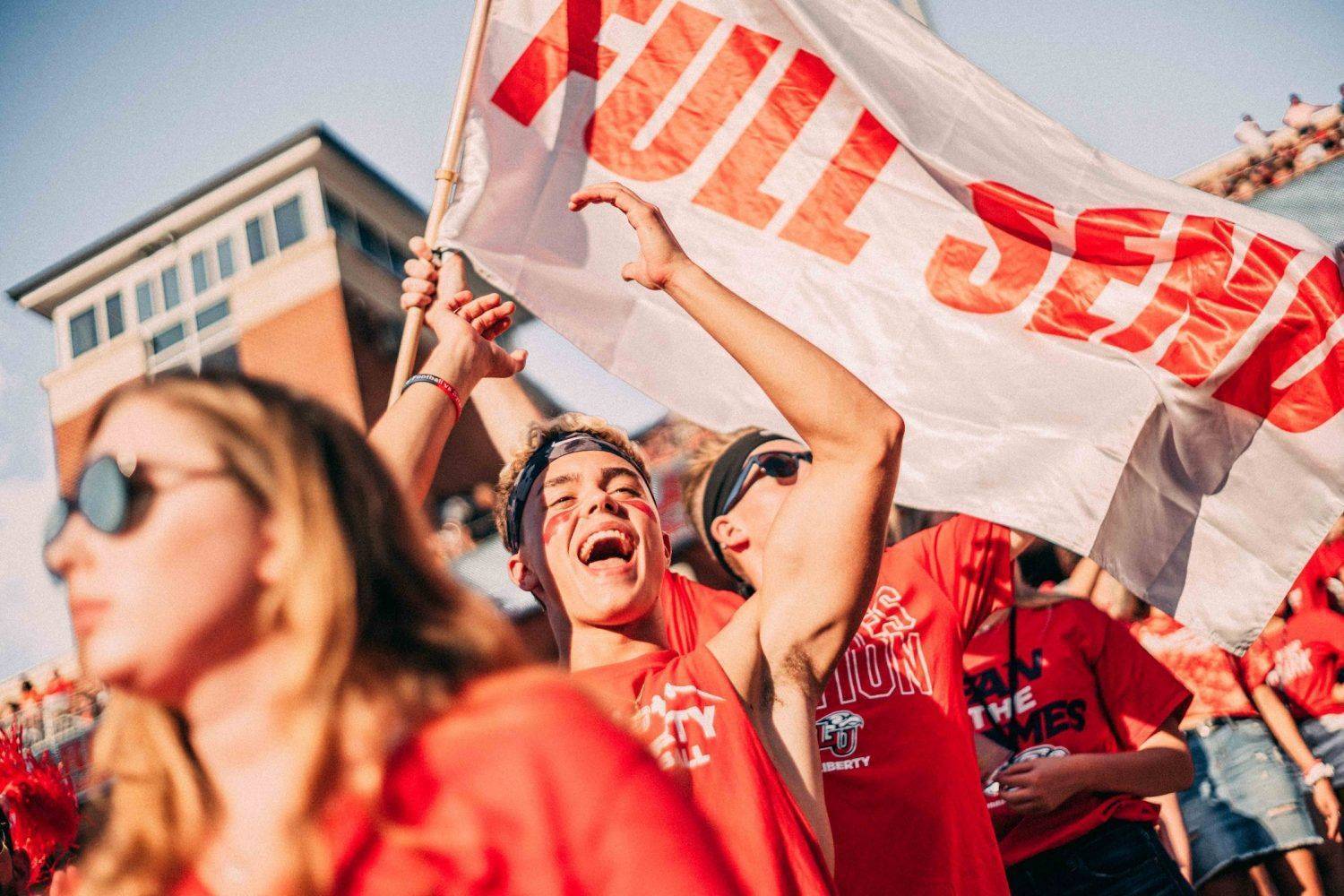 fans dressed in red holding banner