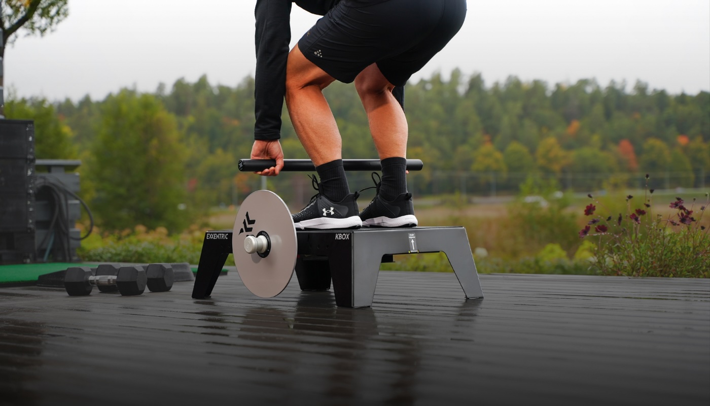 Man on kBox Active doing a deadlift in backyard